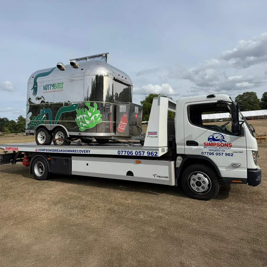 NottyBites catering trailer loaded on a Simpsons Breakdown Recovery flatbed at an outdoor showground with marquees