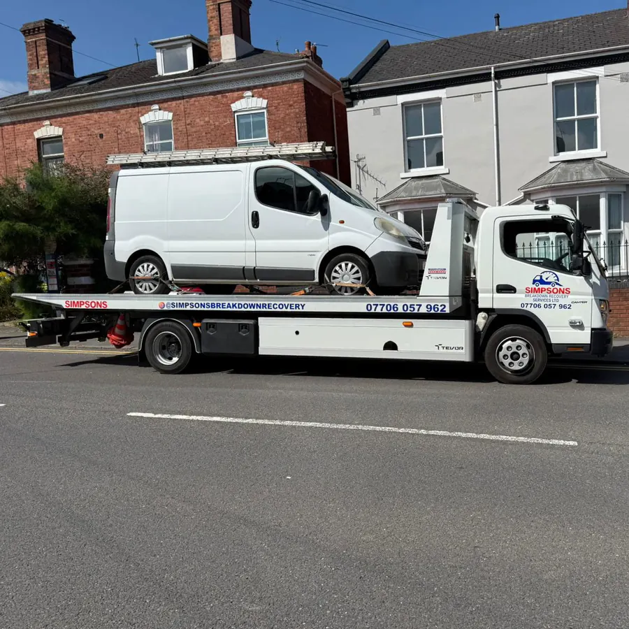 Simpsons Breakdown Recovery flatbed loading a white Renault Trafic work van for transport on a Birmingham residential street